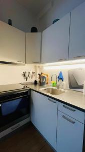 una cocina con armarios blancos y fregadero en ApartmentInCopenhagen Apartment 1314, en Copenhague