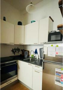 cocina con armarios blancos y nevera de acero inoxidable en ApartmentInCopenhagen Apartment 1314, en Copenhague