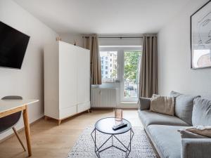 a living room with a couch and a table at Limehome Magdeburg Breiter Weg in Magdeburg