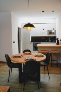 una cocina con mesa de madera con sillas y una cocina con encimera. en Apartamentos Turia Teruel en Teruel