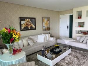 ein Wohnzimmer mit einem Sofa und einem Tisch in der Unterkunft Apartamento Luxo Le Parc in Salvador