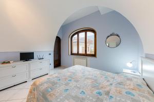 een slaapkamer met een bed, een raam en een tv bij Casa Grillo in Tramonti