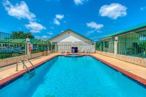a swimming pool on a deck with a house at OYO Hotel Yoakum West in Yoakum
