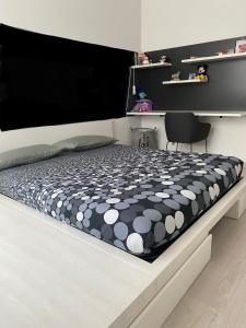 łóżko z czarno-białą kołdrą i krzesłem w obiekcie TORINO CENTRO - La Casa Di Zoe w Turynie