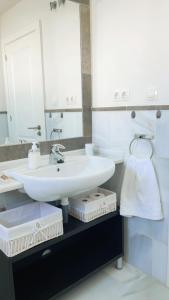 ein Badezimmer mit einem weißen Waschbecken und einem Spiegel in der Unterkunft CASA BAIANA - Dúplex en Costa Ballena in Costa Ballena