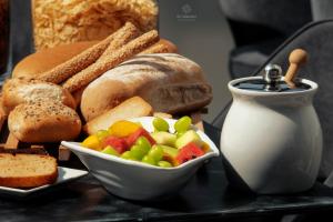 a tray with a plate of bread and a bowl of fruit at 4- you Family in Metamorfosi