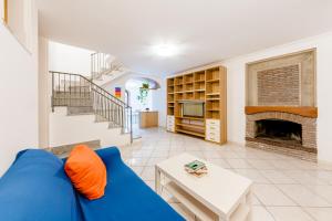 een woonkamer met een blauwe bank en een open haard bij Casa Grillo in Tramonti