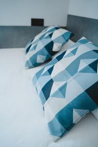 two blue and white pillows sitting on a bed at Apartamentos Turia Teruel in Teruel