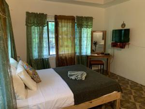 a bedroom with a bed and a table with a mirror at Can Jam Retreat in Negril