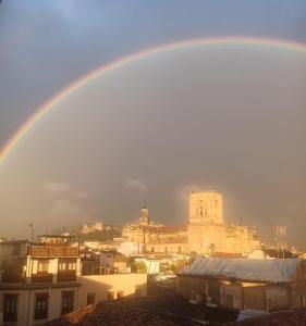 a rainbow in the sky over a city at Pensión Duquesa Bed & Breakfast in Granada