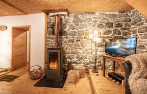d'un salon avec une cheminée et un mur en pierre. dans l'établissement le chalet d'auguste 2 à 12 personnes, à Morzine