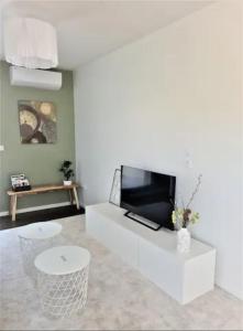 sala de estar con TV de pantalla plana y sofá en Magnifique appartement neuf au centre d'Istres, en Istres