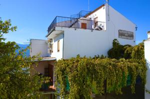 un edificio blanco con balcón y vides en EcoAlbergue Rural de Algodonales, en Algodonales