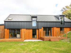 a house with a black roof and a deck at Arenig View in Bala