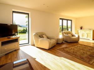 a living room with two chairs and a flat screen tv at Arenig View in Bala