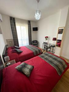 two beds in a room with red sheets at Trastevere Sweet Rest in Rome