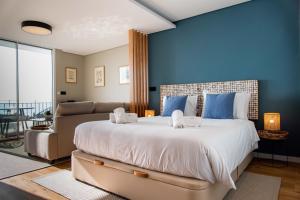 a bedroom with a large bed and a couch at Rooftop Funchal II by Madeira Best Apartments in Funchal