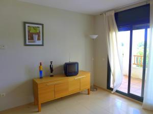 una TV su un comò in una stanza con finestra di Rentalmar Residencial La Cala a Miami Platja