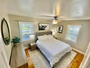 a bedroom with a white bed and two windows at Charming 2 BR 1 BA with outdoor patio and grill close to downtown in Lexington