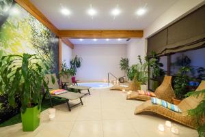 a living room with a tub with plants and chairs at Balia Spa & Wellness in Kazimierz Dolny