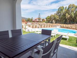 un tavolo e sedie su un patio con piscina di villetta con piscina budoni affitti spiaggia 700 mt a Budoni