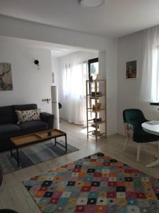 un soggiorno con un divano e un tavolo di BELCARA Apartment a Buşteni
