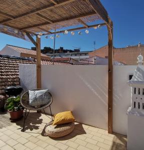 um pátio com uma pérgola, uma cadeira e uma mesa em Algarve house, sun, terrace, views and barbecue em Silves