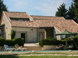 a house with people sitting on chairs near a pool at Gite La Séoune in Monjoi