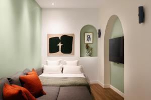 a living room with a couch and a tv at Edgar Suites Notre-Dame - Lagrange in Paris