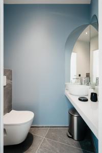 a bathroom with two sinks and a toilet at Edgar Suites Notre-Dame - Lagrange in Paris