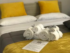 un mucchio di asciugamani sopra un letto di Il Tempio di Athena - Cultura e Relax a Siracusa a Siracusa