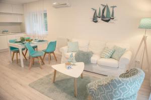 sala de estar con sofá, sillas y mesa en Panoramic apartments en Balatonvilágos