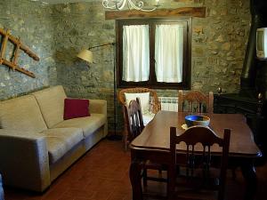 un soggiorno con divano e tavolo di Casa Mur A a Foradada de Toscar