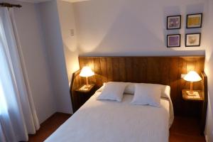 - une chambre avec un lit blanc et 2 lampes dans l'établissement Casa Mur A, à Foradada de Toscar
