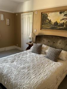 a bedroom with a large bed and a painting on the wall at The Eagle Tavern in Faringdon