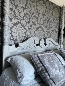 un letto bianco con cuscini in una camera da letto con parete di The Eagle Tavern a Faringdon