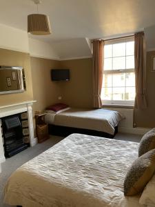 a hotel room with two beds and a fireplace at The Eagle Tavern in Faringdon