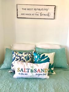 a sign on the wall above a bed with pillows at Beach Daze - Ocean front at Symphony Beach Club! in Ormond Beach