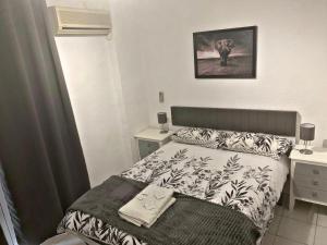 a small bedroom with a bed and two night stands at Barbieri Granada Pensión in Granada