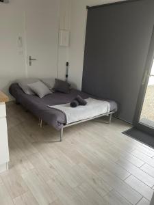 un grande letto in una camera con pavimento in legno di Cabane Miossaise a Mios