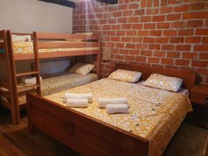 een slaapkamer met 2 stapelbedden en een bakstenen muur bij Vikendica Bajka in Despotovac