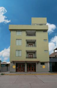 a tall building with orange doors in front of it at Hotel Incasol Agosto Ejecutivo Matrimonial Individual Suite Desayuno Incasol Tranporte y Cochera Gratis in Ayacucho