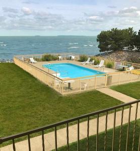a beach with a pool and a fence at Clinton Inn & Suites in Port Clinton