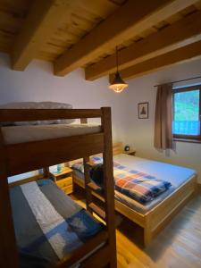 a bedroom with two bunk beds and a window at Chata Klinger in Banská Štiavnica