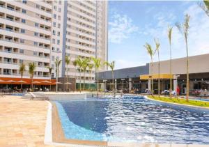 een groot zwembad met palmbomen en gebouwen bij Solar das Águas Park Resort Olímpia in Olímpia