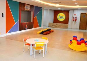 ein Wartezimmer mit Tisch und Stühlen und einem Spielbereich in der Unterkunft Solar das Águas Park Resort Olímpia in Olímpia