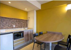 ein Esszimmer mit einem Holztisch und Stühlen in der Unterkunft Solar das Águas Park Resort Olímpia in Olímpia