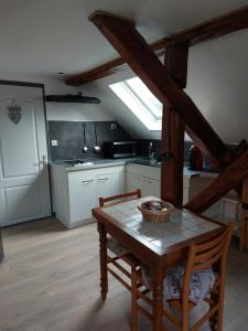 a kitchen with a table and chairs in a room at Les Marmottes in Les Étalons