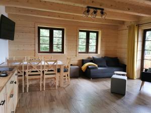 a kitchen and living room with a table and a couch at DOMEK POD CZEREMCHĄ in Zawóz