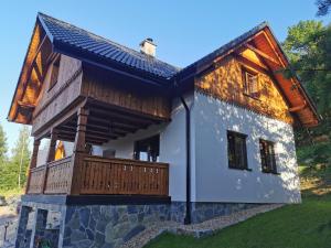 a house with a porch and a balcony at DOMEK POD CZEREMCHĄ in Zawóz